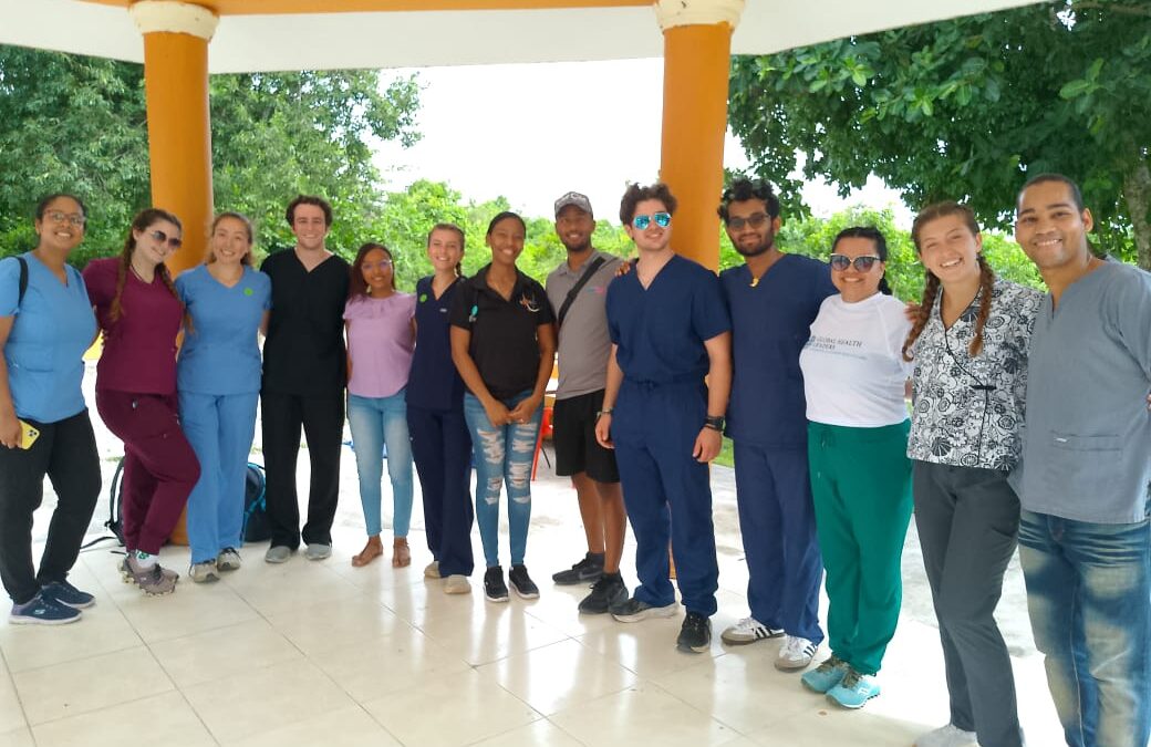 Group of pre-med interns in scrubs and casual attire during a medical internship in the Dominican Republic, showcasing teamwork and cultural engagement in healthcare.