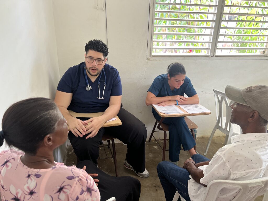 Healthcare interns engaging with patients in a clinical setting, discussing medical protocols and patient welfare, highlighting the importance of hands-on experience in medical research and networking in healthcare.